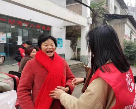 图为实践团队成员在分发围巾（钱程  摄）